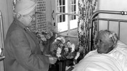 Black and white photo of A visitor with flowers, around the year 1956.