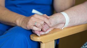 Nurse holding hands with patient