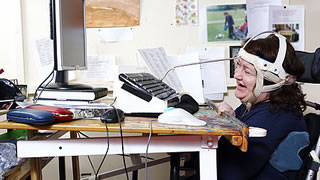 Person using head apparatus to operate a keyboard