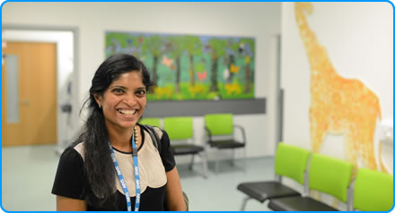 A consultant paediatric neurologist standing in the waiting room of a hospital clinic