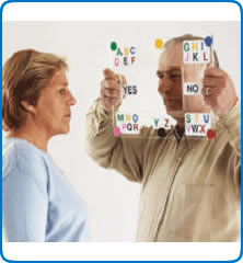 Man holding a clear, plastic board with letters in each corner called an E-Tran in front of a woman