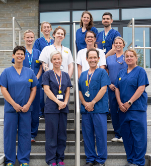 10 members of the vascular testing team stand on stair in 3 rows