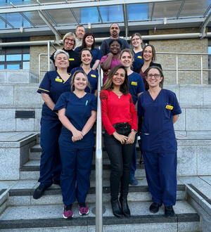 14 members of NBT staff stood on stairs posing for a photo