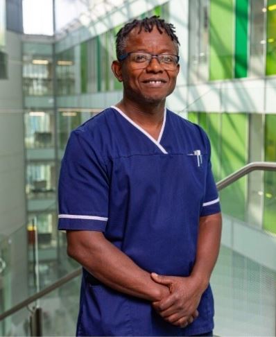 Edward Mabgwe, Emergency Nurse Practitioner at NBT, standing in uniform by a stairwell in the Brunel Building