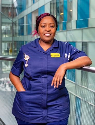 Evalyne Gichanga, Registered Nurse, standing in NBT's Brunel building in uniform