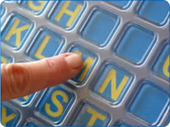 Close up shot of finger touching the letter M on a Frenchay Alphabet Board