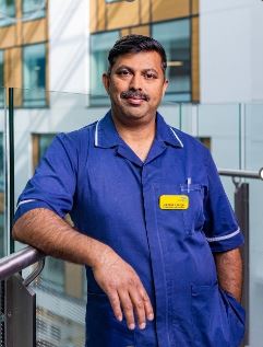 Jaimon George, Senior Charge Nurse at NBT, standing in uniform in the hospital's Brunel building