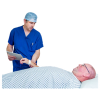 Patient wearing a hospital gown lying on a bed. An anaesthetist in blue uniform and a theatre hat is touching the patient's wrist.