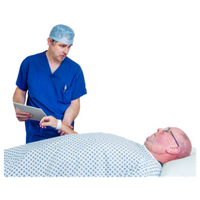 Image of a patient and anaesthetist Patient wearing a hospital gown lying on a bed. An anaesthetist in blue uniform and a theatre hat is touching the patient's wrist.