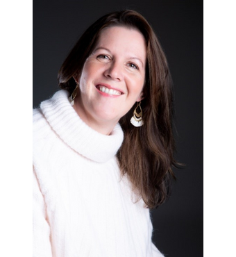 Rebecca Winterborn smiling at the camera wearing a white jumper