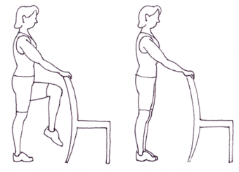 Person standing behind chair with one leg raised 