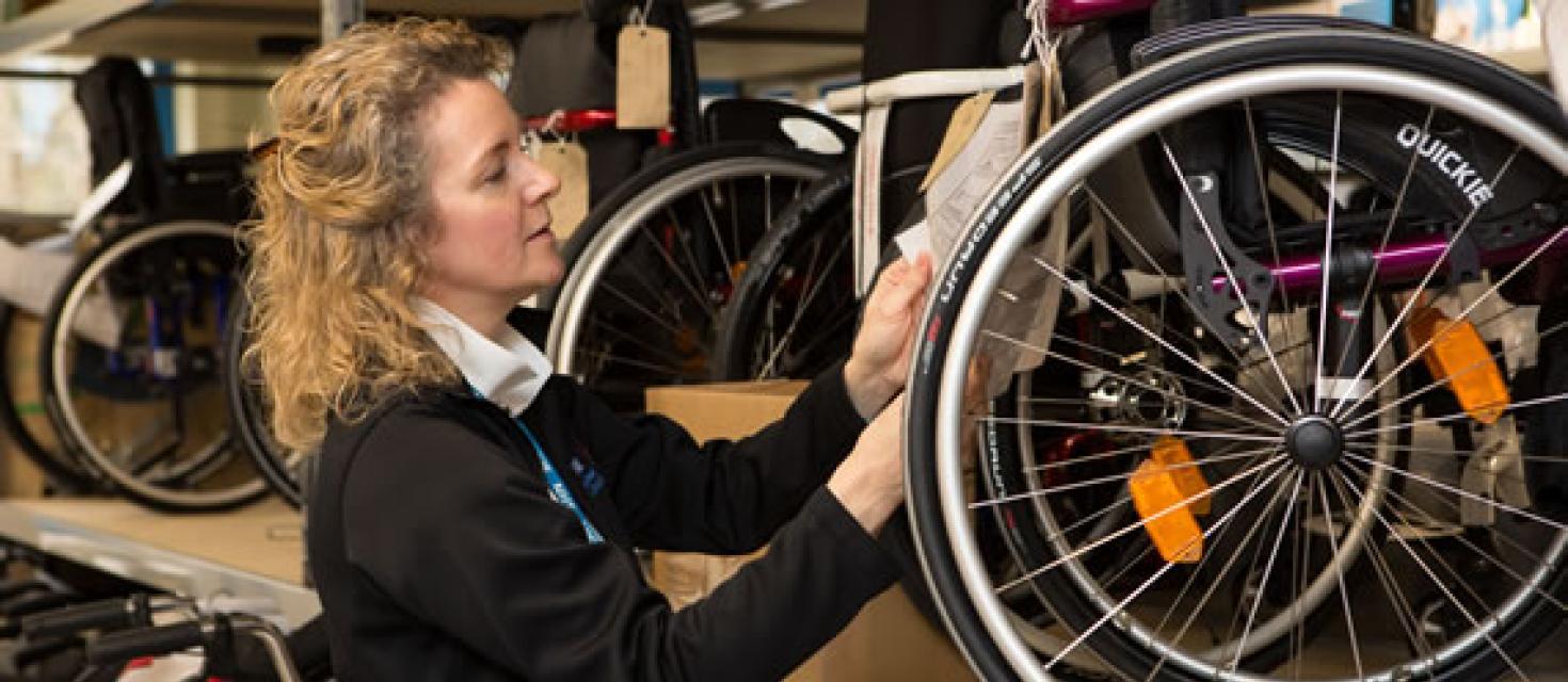 Lady looking at a wheelchair wheel