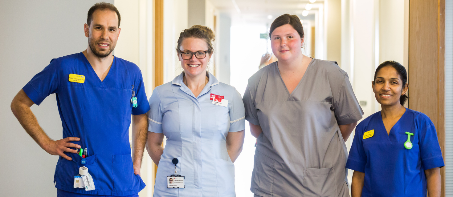 Four nurses standing next to each other and smiling