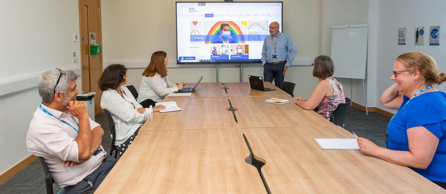 Senior Leadership team in meeting room for a presentation