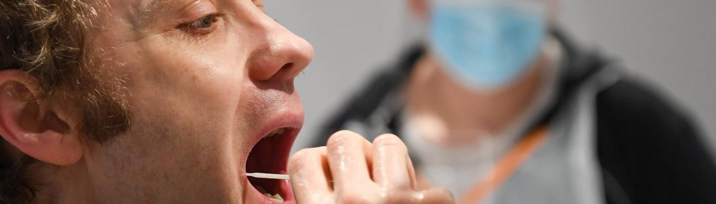 Patient performing a mouth swab