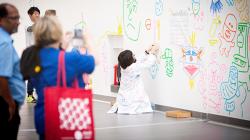 Japanese artist Daichi Konaka creates a washi tape mural in the atrium.
