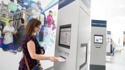 Patient check in machine with lady in front of it