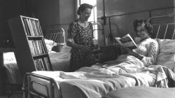 Black and white photo of A patient choosing books from the Southmead mobile library.