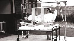 Black and white photo of Patient lifting equipment outside the hospital.