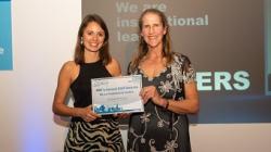 Two women on stage holding a certificate