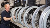 Man looking along a line of wheelchair wheels