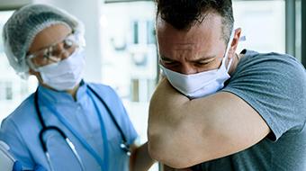 Patient coughing into the crease of his arm