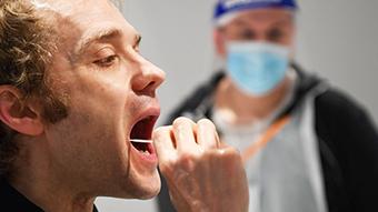 Patient performing a mouth swab