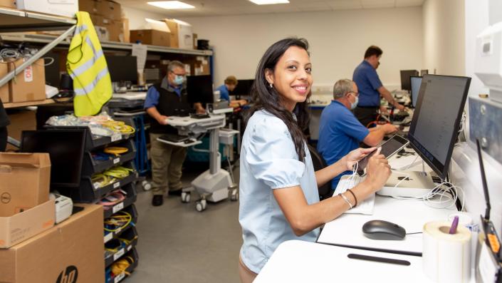 Lady fixing a broken tablet device in an IT support room