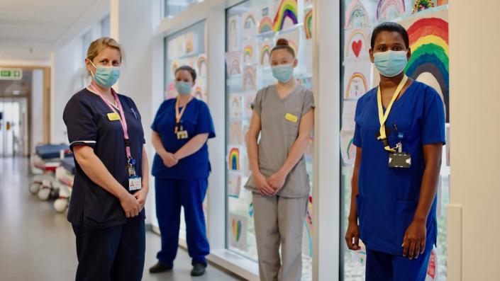 Nurse team standing with Rainbows behind them