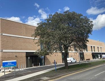 A brick building with a tree in front. 