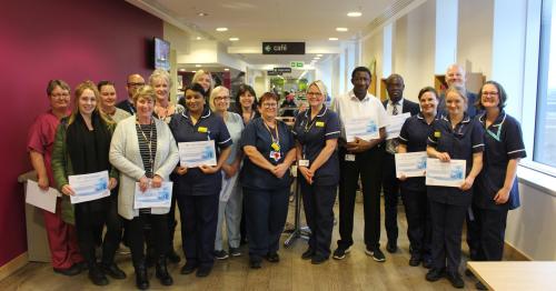 Image of a group of staff members holding certificates Image of a group of staff members holding certificates