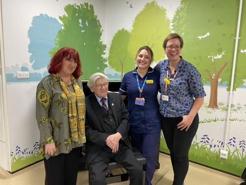 Fiona, Harry, Beth Deverson (senior sister in Elgar Enablement Unit) and Laura Tanner (Music manager at NBT) are pictured standing in front of the new piano smiling.