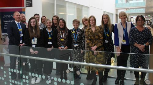Chief Executive, Maria Kane, stood smiling alongside the apprenticeship delivery team.