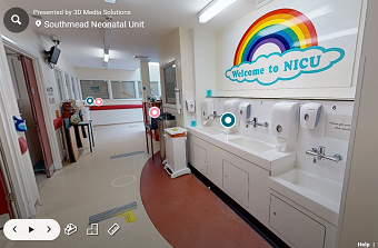 A sign depicts a colourful rainbow, underneath it says welcome to NICU, there are handwashing basins below the sign and a corridor stretching ahead in front