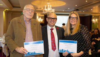 Two men and women stood together, two holding certificates