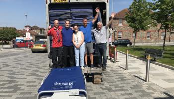 NHS North Bristol Trust staff members standing outside a truck full of mattresses to be sent to Ukraine hospitals.