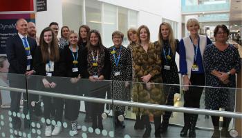 Chief Executive, Maria Kane, stood smiling alongside the apprenticeship delivery team.