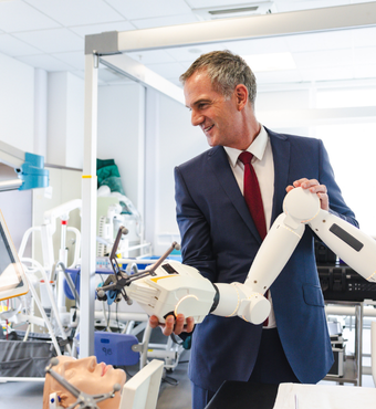 Secretary of State, Peter Kyle MP, holds a white robotic surgical arm